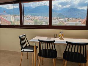 a table with three chairs in front of a large window at Luxury suite with Olympus and sea view in Litochoro