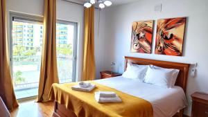 a bedroom with a bed and a large window at Vista Mar Concórdia by Rentallido in Funchal +13 photos