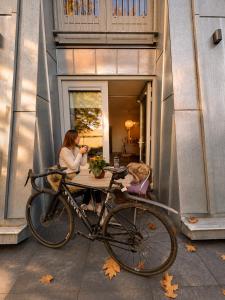 a woman sitting at a table with a bike at De Meuleberg Boutique Suites in Melick
