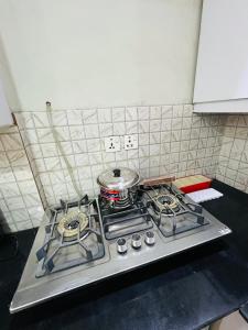 a kitchen stove with a pot on top of it at Royal Stays 2Bed Cozy Apartment in Multan