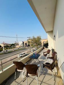 a balcony with chairs and a table with a view of a highway at Royal Stays 2Bed Cozy Apartment in Multan