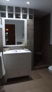 a bathroom with a white sink and a mirror at Casa Rural Valdezaque in Cordobilla de Lácara +30 photos