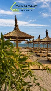 a group of straw umbrellas on a beach at Luxury by White Titanic Breeze in Năvodari