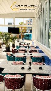 a row of tables and chairs in a restaurant at Luxury by White Titanic Breeze in Năvodari