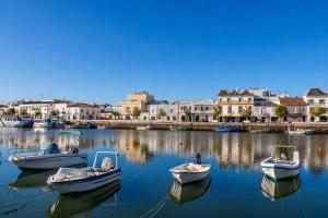 four boats are docked in the water in a harbor at Kampaoh Tavira in Tavira +37 photos