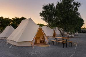 a group of tents in a parking lot with a table at Kampaoh Tavira in Tavira