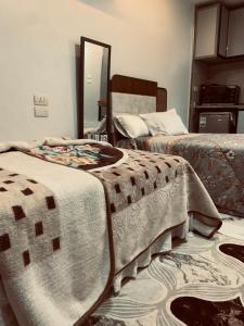 a bedroom with two beds and a mirror at Studio in Porto Said Compound in Port Said +37 photos