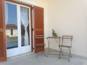 a table and two chairs in front of a window at Olive terra holiday aparments in Lefkimmi +30 photos