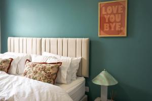 a bedroom with a white bed with a blue wall at Park House by Tŷ SA in Aberdare +27 photos