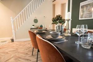 a dining room with a black table and chairs at Park House by Tŷ SA in Aberdare