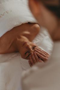 a woman laying in bed with her hands on her face at Château de Valmer in La Croix-Valmer
