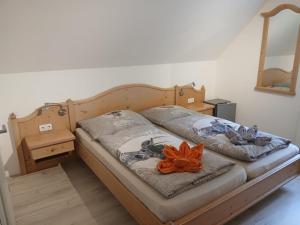 a bed with an orange flower on top of it at Plösch Hof in Weinberg