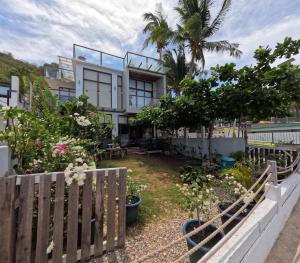 a house with a fence and some plants at The Reef Anilao in Mabini