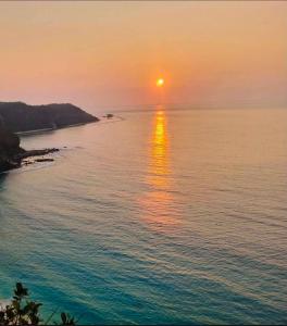 a sunset over the water with the sun in the sky at The Reef Anilao in Mabini