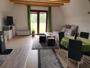 a living room with a table and a couch at ZELENI BOR koliba vikendica Pale in Pale