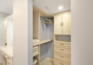 a walk in closet with wooden cabinets and towels at GBB 1335 Stunning Harbor View Condo on Siesta Key in Siesta Key +35 photos