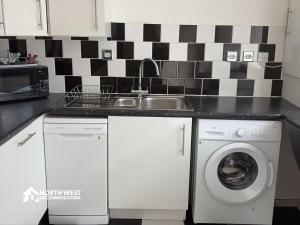 a kitchen with a sink and a washing machine at Warrington 3-Bedroom House Near Birchwood & Omega in Warrington +12 photos