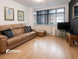 a living room with a couch and a flat screen tv at Warrington 3-Bedroom House Near Birchwood & Omega in Warrington