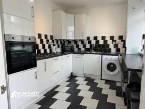 a kitchen with a black and white checkered floor at Warrington 3-Bedroom House Near Birchwood & Omega in Warrington