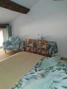 a bedroom with a table and chairs and a bed at Chambre - A La Maison Du Bonheur in Lanty-sur-Aube