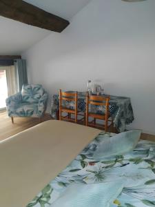 a living room with a table and chairs and a bed at Chambre - A La Maison Du Bonheur in Lanty-sur-Aube