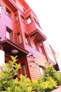 un gran edificio de madera con un cartel. en Eskibağ Butik Hotel, en Büyükada