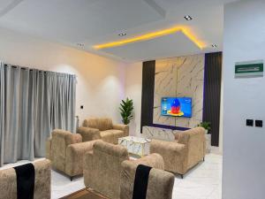 a living room with couches and a flat screen tv at Esthella Property in Ijaiye
