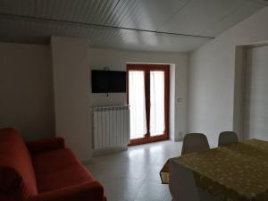 a living room with a red couch and a window at House biase e marrys in Trecchina