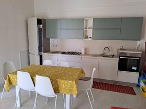 a kitchen with a dining table and white chairs at House biase e marrys in Trecchina