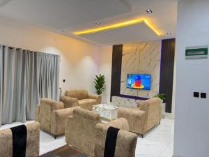 a living room with couches and a flat screen tv at Esthella Property in Ijaiye +6 photos