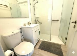 a bathroom with a toilet sink and a shower at Estoril 2 bd by the Beach in Estoril