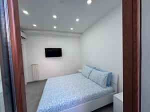a small bedroom with a bed and a tv at La dimora dei Giglianti in Brusciano