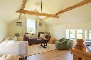 a living room with a couch and a table at Scenic Barn Conversion in Rural Shropshire in Craven Arms