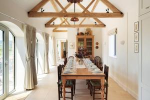 a dining room with a long table and chairs at Scenic Barn Conversion in Rural Shropshire in Craven Arms +19 photos