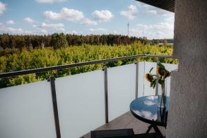 a balcony with a table and a view of a forest at Panorama Silva in Augustów