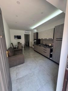a living room with a couch and a kitchen at La dimora dei Giglianti in Brusciano