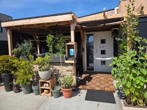 a house with a pergola with potted plants at Vakantiehuisje van Orten in Sint Annaland