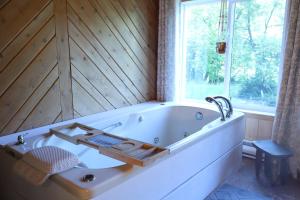 a bath tub in a bathroom with a window at Slo-Brome gîte de charme slow life in Lac-Brome