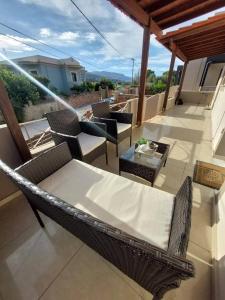 a patio with a table and chairs on a balcony at The Mastiha Spot 5 in Chios