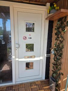 a white door with two pictures on it at Vakantiehuisje van Orten in Sint Annaland