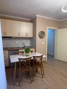 a kitchen with a table and chairs and a clock on the wall at Berat Central Home in Berat