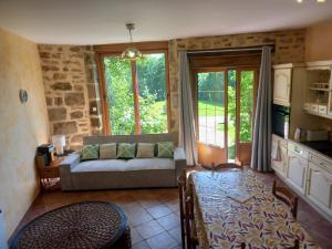 a living room with a couch and a large window at le gite du jardinier in Saint-Martin-lʼAiguillon