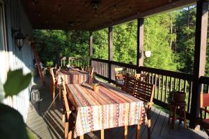 a porch with two tables and chairs on it at Slo-Brome gîte de charme slow life in Lac-Brome