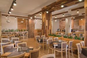 ein Restaurant mit Tischen und Stühlen in einem Raum in der Unterkunft Hotel Alba - All inclusive in Sonnenstrand