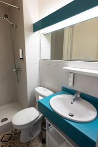 a bathroom with a sink and a toilet and a mirror at L'Auberg'ine - Maison Glenn Anna in Sainte Anne d'Auray +41 photos