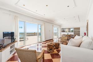 a living room with a couch and a view of the ocean at Punta Prima Apartments by 3VILLAS in Punta Prima