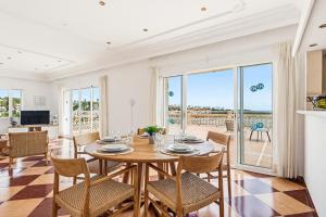 a dining room with a table and chairs with a view at Punta Prima Apartments by 3VILLAS in Punta Prima