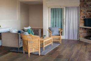a living room with two chairs and a couch at Fabella Serenety Flat in Muizenberg