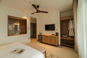 a bedroom with a bed and a flat screen tv at dei Balconi Dalat in Ấp Ða Lợi