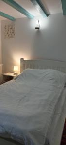 a bed with a white blanket on it in a bedroom at Casa cu Turn in Sărata-Monteoru